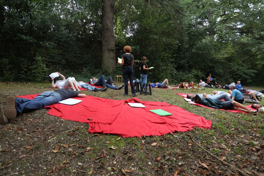 Les 2 lectrices de Nous verrons mieux pendant le RDV du dimanche dans la forêt de Bassens. Allongés dans l'herbe, les gens écoutent l'histoire…